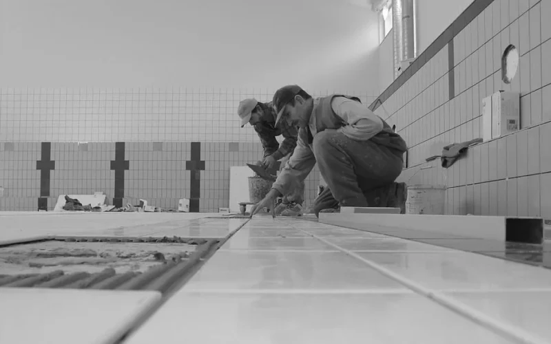 Professional workers tiling a bathroom interior, showcasing expertise in construction.