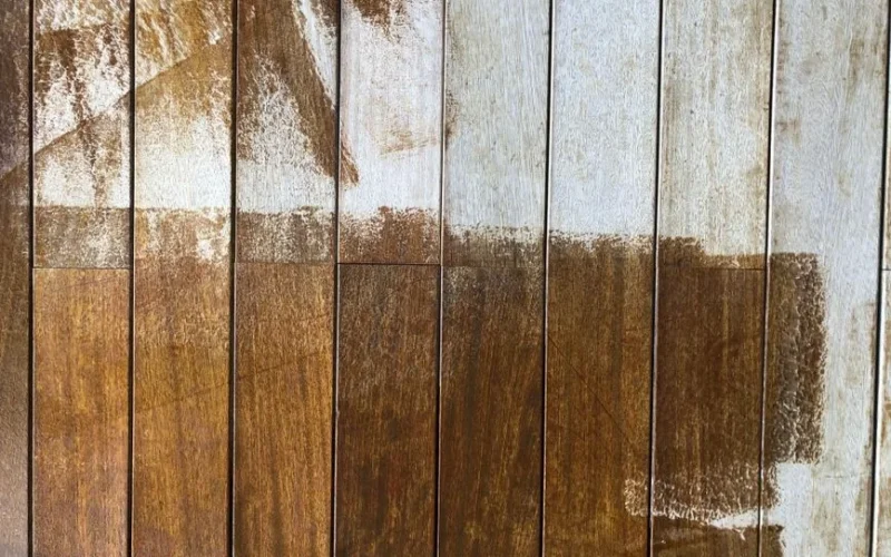 Close-up of a rustic wooden fence with peeling white and brown paint, highlighting texture.