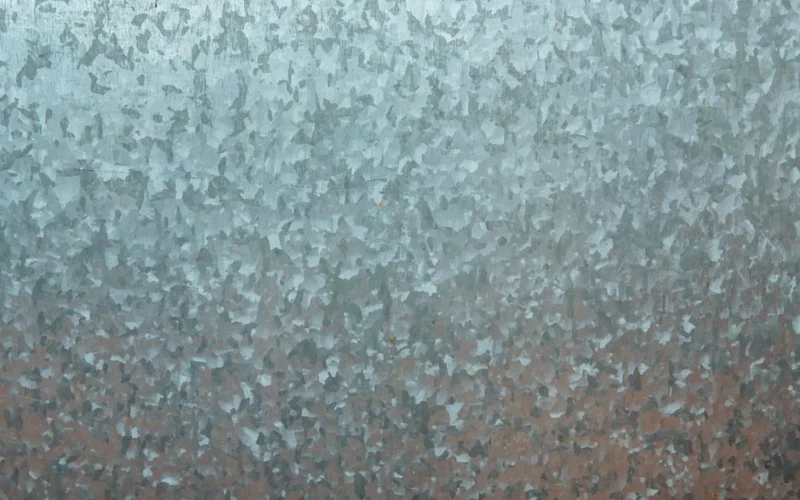 Close-up of a textured galvanized steel surface, showcasing its unique metallic pattern.