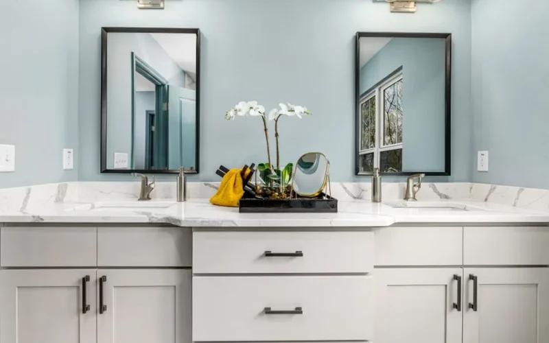 A serene modern bathroom featuring twin sinks, elegant faucets, and decorative mirrors.