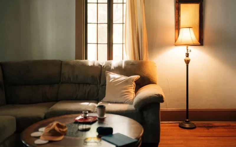 A warm, inviting living room interior featuring a sofa, coffee table, and floor lamp.