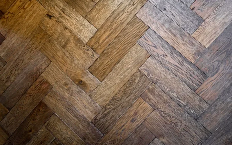 Stylish herringbone parquet floor pattern in warm wood tones, perfect for interior design inspiration.