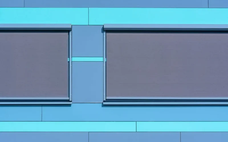 Minimalist blue facade featuring modern roller blinds for architectural appeal.