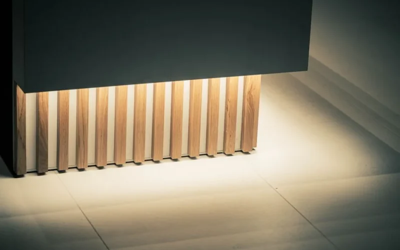 Elegant architectural element featuring illuminated wooden slats against a sleek paneling. Ideal for contemporary design concepts.