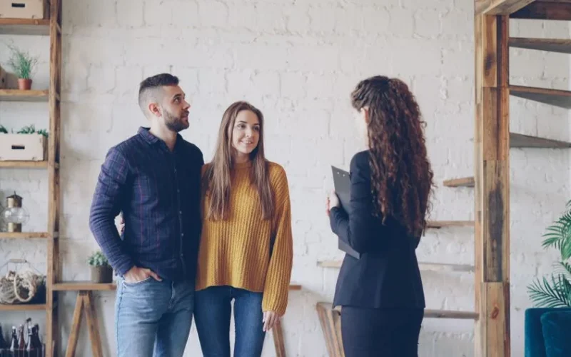 Young couple consulting a real estate agent in modern interior setting.