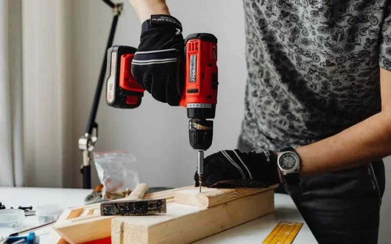 A skilled craftsman working on a wooden piece using a power drill, showcasing precision and expertise.