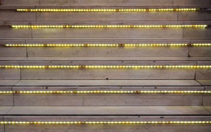 Close-up of a staircase with glowing LED lights on each step, creating a modern look.