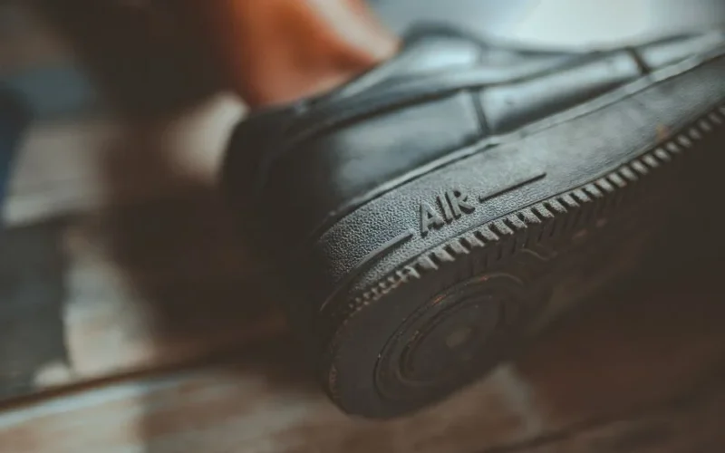 Close-up of a black sneaker sole showing text 'Air.' Focus on details and texture of the rubber material.