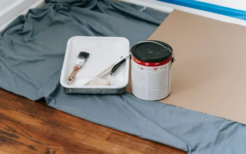 A collection of painting tools and materials prepared for a home renovation project indoors.
