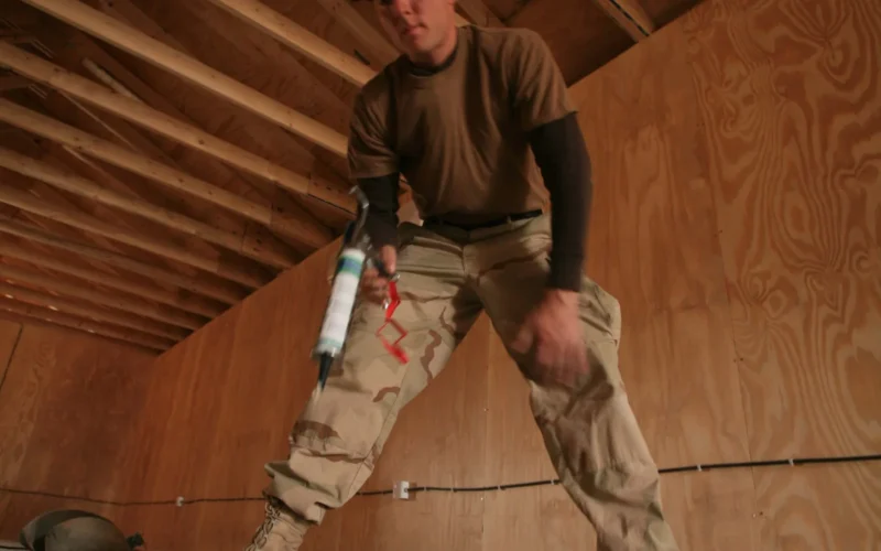 With the Seabees "can do" attitude, Petty Officer 2nd Class Brad K. Bazemore, a utilitiesman with Naval Mobile Construction Battalion One, Detachment Al Taqaddum, ensures enough adhesive is applied to the cement foundation for the wooden flooring to stay connected. Bazemore worked a variety of jobs while constructing the new church, as many Seabees do when they take on a job, multi-tasking and multi-training to get the job done effectively.
