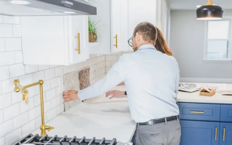 A couple choosing tiles in a modern kitchen setting, discussing renovation ideas.