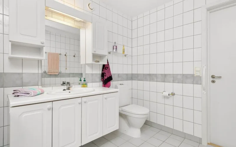 Bright and clean modern bathroom with white tiles and minimalistic decor.