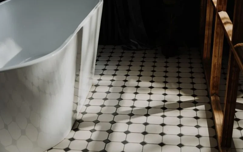 Minimalist bathroom with a freestanding tub and stylish hexagonal floor tiles, showcasing modern design.