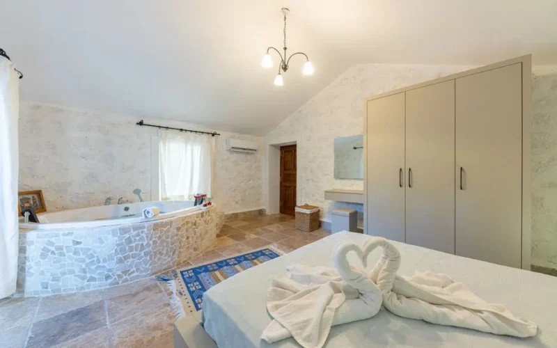 Spacious bedroom interior featuring elegant bathtub, cozy bed, and modern wardrobe.