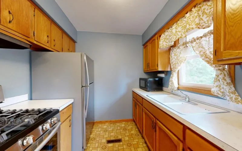 Warm, vintage-inspired kitchen with wooden cabinets and tiled floor, perfect for home cooking enthusiasts.