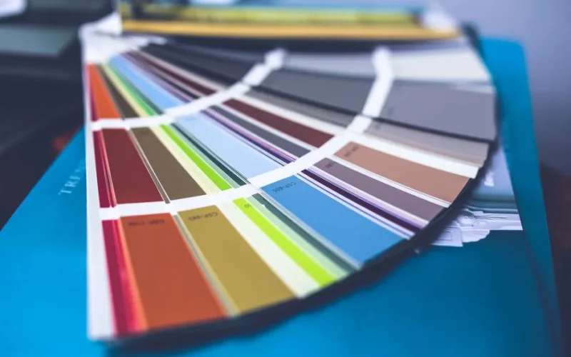 A collection of colorful paint swatches spread out showcasing a variety of hues.