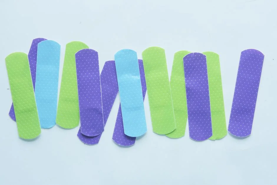 Colorful band-aids arranged on a white surface, perfect for health and safety themed projects.