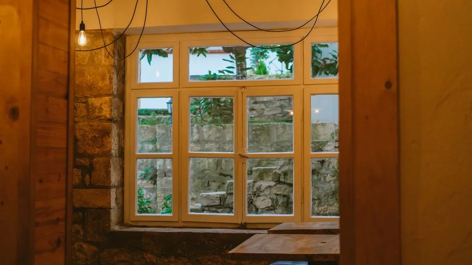 Warm and inviting indoor setting featuring rustic elements and a view through a large window.
