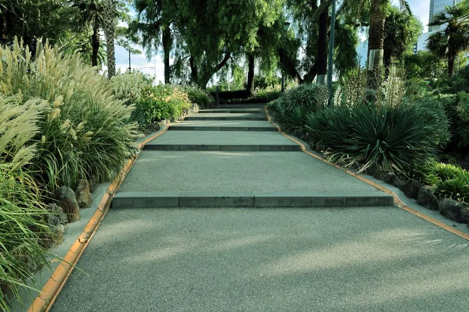 Peaceful garden pathway surrounded by vibrant plants and trees, perfect for relaxation.