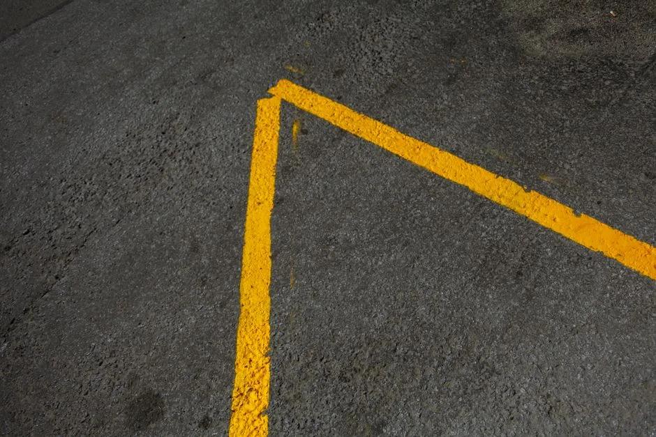 From above of abstract background of asphalt road with yellow lines in daytime