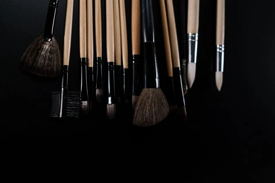 Close-up of various makeup brushes on a black background, ideal for beauty and fashion concepts.
