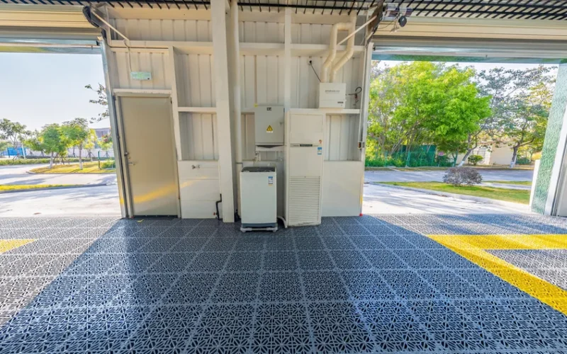 Spacious open garage with durable metal grid flooring and equipment setup facing outdoors.