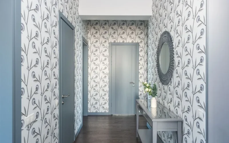 A stylish hallway featuring floral wallpaper, a console table, and a decorative mirror.