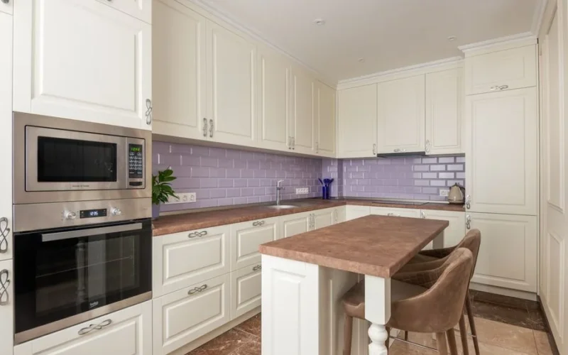 Stylish white kitchen featuring marble countertops and a microwave. Perfect for modern interiors.