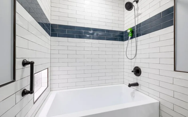 Sleek, minimalist bathroom with white and blue tiles and contemporary fixtures.