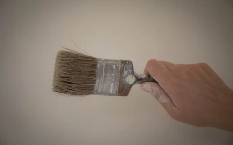 Hand gripping a paintbrush, ready for painting. Ideal for artistic themes.