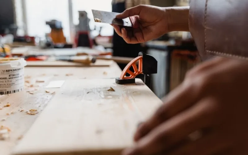 Close-up of a craftsman's hands at work in a woodworking studio. Precision and skill on display.
