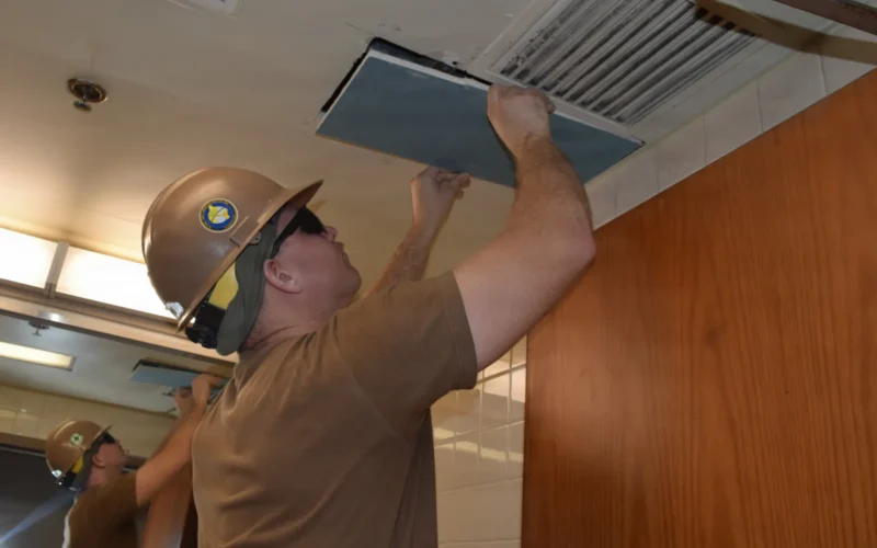 Builder 2nd Class Anthony Puch, assigned to Naval Mobile Construction Battalion (NMCB) 4, patch a hole in a drywall ceiling in support of office renovations at Osan Airforce Base, Osan, South Korea, on September 15, 2025. NMCB 4 is forward deployed throughout the Indo-Pacific region to support and maintain a free and open Indo-Pacific. As the stand-in, crisis response, naval engineering force, NMCB 4 maintains a ready posture to deliver in-theater expeditionary logistics via expeditionary shore infrastructure, forward damage repair, and mobile construction. (US Navy Photo by Builder 3rd Class Valera Cecan)
