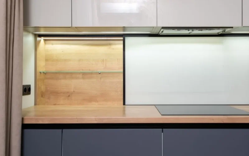 Cook top built in wooden table under cupboard with hood in modern light house kitchen