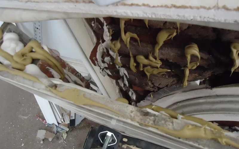 This is looking down from about six feet, at a broken left side of a fireplace. The exterior shell was loose. So I added construction adhesive inside after vacuuming out the dust and broken bits of masonry. Next step was to push it closed.