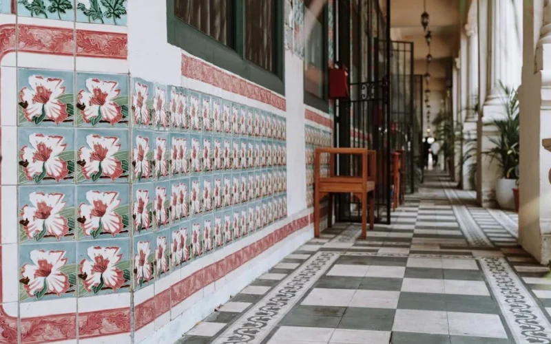 Long corridor featuring ornate floral tiles and vintage decor, capturing architectural elegance.