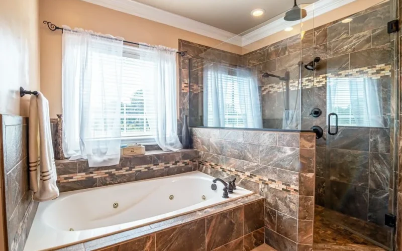 Elegant bathroom featuring a large bathtub and walk-in shower with marble tiles.