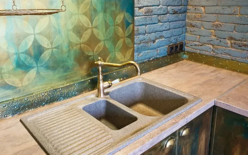 Cozy kitchen interior featuring a rustic double sink, decorative brick wall, and vibrant backsplash.